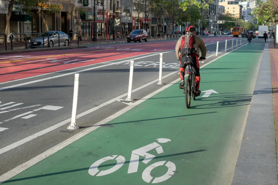 A cyclist commutes along a painted bike lan on Market Street in San Francisco.
